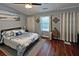 Bedroom with hardwood floors, queen bed with decorative bedding, and natural light at 440 Berckman Nw Dr, Lilburn, GA 30047