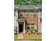 Brick townhome with a covered entrance, well-kept lawn, and classic architectural details at 440 Berckman Nw Dr, Lilburn, GA 30047