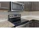 Kitchen features stainless steel oven, microwave, granite countertops, and subway tile backsplash at 440 Berckman Nw Dr, Lilburn, GA 30047