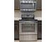 Stainless steel oven is set below stainless steel microwave, surrounded by subway tile at 440 Berckman Nw Dr, Lilburn, GA 30047