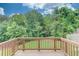 Outdoor deck with wooden railings and a lush green view at 1727 Shire Village Dr, Sugar Hill, GA 30518