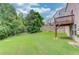 Spacious backyard with mature trees and green grass at 1727 Shire Village Dr, Sugar Hill, GA 30518