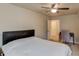 This is a bedroom with a ceiling fan, and desk with chair, and neutral walls at 1727 Shire Village Dr, Sugar Hill, GA 30518