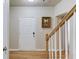 Bright foyer with hardwood floors, white door and banister, and a decorative picture at 1727 Shire Village Dr, Sugar Hill, GA 30518
