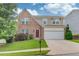 Charming two-story home with a brick facade, manicured lawn, and a two-car garage at 1727 Shire Village Dr, Sugar Hill, GA 30518