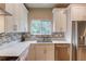 Bright kitchen with stainless steel appliances, white cabinets, and mosaic tile backsplash at 1727 Shire Village Dr, Sugar Hill, GA 30518
