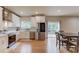 Modern kitchen with white cabinets, stainless steel appliances, and an open dining area at 1727 Shire Village Dr, Sugar Hill, GA 30518