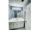 Well-lit bathroom featuring white cabinetry, a large mirror and shower at 2640 Preston Ridge Ln, Dacula, GA 30019