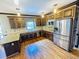 Spacious kitchen features stainless steel appliances, granite counters, and wood cabinets and floors at 2640 Preston Ridge Ln, Dacula, GA 30019