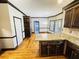 Open kitchen with wooden floors and cabinets and granite countertop island with dining area at 2640 Preston Ridge Ln, Dacula, GA 30019