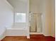 Well-lit bathroom featuring a soaking tub and a glass-enclosed shower at 2647 Midler Ct, Buford, GA 30519