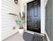 Inviting entryway featuring a dark front door, white siding, a decorative plant, and a charming welcome mat at 2647 Midler Ct, Buford, GA 30519