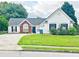 Charming single-Gathering home with a well-manicured lawn, attached garage and a classic brick and vinyl facade at 2647 Midler Ct, Buford, GA 30519