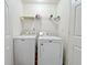 Functional laundry room with a washer, dryer, and storage shelf at 2647 Midler Ct, Buford, GA 30519