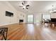 Open living room with a fireplace, ceiling fan, hardwood floors, and a view into the dining area at 2647 Midler Ct, Buford, GA 30519
