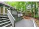 View of the back deck with stairs leading down to the backyard, surrounded by lush trees at 425 Bellflower Ct, Roswell, GA 30076