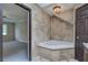 Bathroom showcasing a luxurious corner bathtub, tile surround, and doorway view into bedroom at 425 Bellflower Ct, Roswell, GA 30076