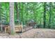 Backyard wooden playground with a gazebo surrounded by lush greenery at 425 Bellflower Ct, Roswell, GA 30076