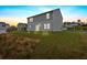View of backyard featuring an attached home with gray siding, an expansive green yard, and an open view at 600 Tudor St, Kingston, GA 30145