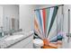 Well-lit bathroom with a granite countertop vanity, white toilet, and a vibrant sunrise patterned shower curtain at 600 Tudor St, Kingston, GA 30145