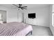 Bright bedroom features a ceiling fan, modern dresser with a flat screen TV and a view to the ensuite bathroom at 600 Tudor St, Kingston, GA 30145