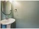 Simple powder room with a pedestal sink and a large round mirror at 1536 Liberty Nw Pkwy, Atlanta, GA 30318