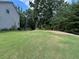 Large grassy backyard next to a wooded area with a wooden fence at 17 Kola Ln, Rydal, GA 30171