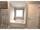 Bathroom showcasing a tub with shower curtain and a window for natural light at 17 Kola Ln, Rydal, GA 30171