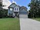 Charming two-story home with blue siding, well-manicured lawn, and attached two-car garage at 17 Kola Ln, Rydal, GA 30171