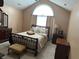Cozy bedroom featuring a decorative iron bed frame and large arched window at 2191 Rockbridge Road # 2603, Stone Mountain, GA 30087