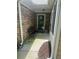 Covered front porch with a wrought iron bench, stone facade, and the house number above the door at 2191 Rockbridge Road # 2603, Stone Mountain, GA 30087