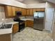 Well-lit kitchen boasts stainless steel appliances, light wood cabinets, and tile flooring at 2191 Rockbridge Road # 2603, Stone Mountain, GA 30087