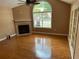 Bright living room with a fireplace, large window, and pristine hardwood flooring at 2191 Rockbridge Road # 2603, Stone Mountain, GA 30087
