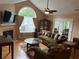 Cozy living room with hardwood floors, a ceiling fan, large windows, and a fireplace with TV mounted above at 2191 Rockbridge Road # 2603, Stone Mountain, GA 30087