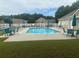 Community swimming pool surrounded by chairs and umbrellas at 2191 Rockbridge Road # 2603, Stone Mountain, GA 30087