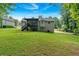 View of the home's backyard with lush green grass and a charming deck area for outdoor relaxation at 225 Hitchcock Dr, Villa Rica, GA 30180