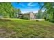 Expansive backyard featuring lush greenery, a charming deck, and a convenient two-car garage at 225 Hitchcock Dr, Villa Rica, GA 30180