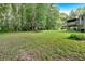 Expansive backyard with lush green grass, mature trees, and a wooden deck, perfect for outdoor activities at 225 Hitchcock Dr, Villa Rica, GA 30180
