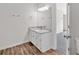 A well-lit bathroom features a vanity with drawers, a large mirror, and wood-look flooring at 225 Hitchcock Dr, Villa Rica, GA 30180