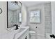 Updated bathroom featuring marble-look tile, black hardware, and a modern vanity with quartz countertop at 2502 Tupelo Se St, Atlanta, GA 30317