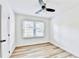 Light-filled bedroom showcasing modern light wood floors, a ceiling fan, and a large window at 2502 Tupelo Se St, Atlanta, GA 30317