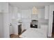 Modern kitchen with white cabinets, quartz countertops, stainless steel appliances, and stylish light fixtures at 2502 Tupelo Se St, Atlanta, GA 30317
