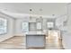 Modern kitchen with stainless steel appliances, gray kitchen island, white cabinets, and elegant pendant lighting at 2502 Tupelo Se St, Atlanta, GA 30317