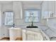 Modern kitchen featuring white cabinetry, marble countertops, subway tile backsplash, and stainless sink at 2502 Tupelo Se St, Atlanta, GA 30317