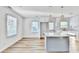 Open-concept kitchen with island, sleek white cabinetry, modern pendant lights, and wood-look floors at 2502 Tupelo Se St, Atlanta, GA 30317