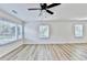 Bright, open living room with wood-look flooring, ceiling fan, and an abundance of natural light from multiple windows at 2502 Tupelo Se St, Atlanta, GA 30317