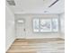 Bright living room with wood-look floors, large window, and white door at 2502 Tupelo Se St, Atlanta, GA 30317