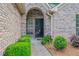 Charming front entrance with a brick archway, decorative door, and manicured landscaping at 425 Greenmont Walk Ct, Alpharetta, GA 30009