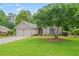 Charming brick home with a well-manicured lawn and a mature shade tree at 425 Greenmont Walk Ct, Alpharetta, GA 30009
