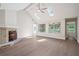 Bright living room featuring a brick fireplace, ceiling fan, skylights, and hardwood floors at 425 Greenmont Walk Ct, Alpharetta, GA 30009
